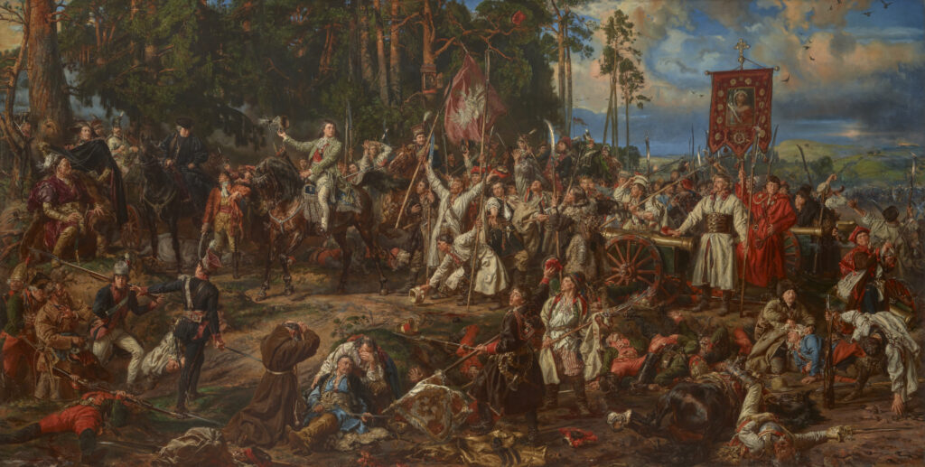 Duże olejne płótno przedstawiające zatłoczoną scenę bitewną: centralnie jeździec w ozdobnym stroju na koniu otoczony przez szeregi żołnierzy i dowódców niosących proporce i broń, po lewej gęsty las, po prawej armaty i wóz, na pierwszym planie ranni i polegli rozrzuconi na ziemi oraz porzucone sztandary, a w tle chmurne niebo i rozległy pagórkowaty krajobraz.
