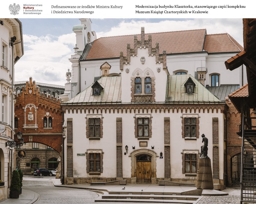 Widok dziedzińca z centralnym białym historycznym budynkiem o dekoracyjnym schodkowym szczycie, patynowanym zielonym dachu, ozdobnymi oknami i drewnianymi drzwiami; po lewej ceglany łuk przejściowy, po prawej figura rzeźbiarska na cokole, brukowany plac ze stopniami i kilkoma gołębiami oraz widoczny u góry biały pas z oficjalnymi napisami.