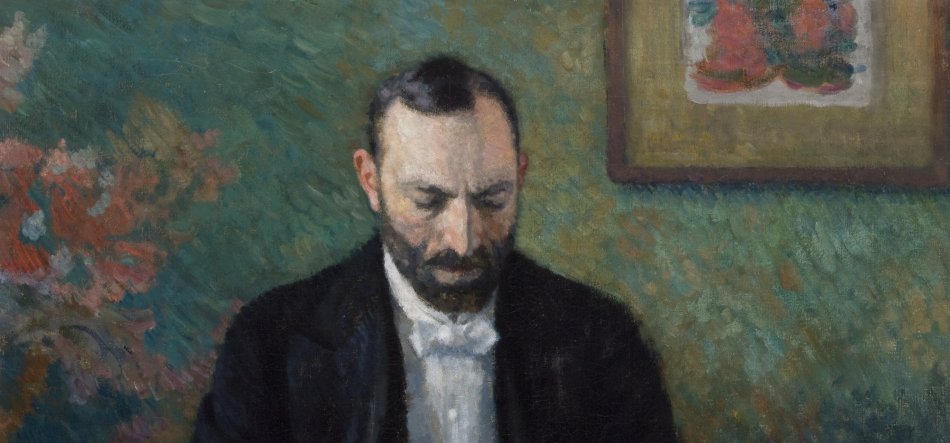 Obraz przedstawia mężczyznę z krótkimi ciemnymi włosami i ciemną brodą, w czarnej marynarce i białej koszuli, z pochyloną głową i wzrokiem skierowanym w dół, na tle zielonej, fakturowanej ściany z kolorowymi plamami po lewej i oprawionym rysunkiem po prawej.