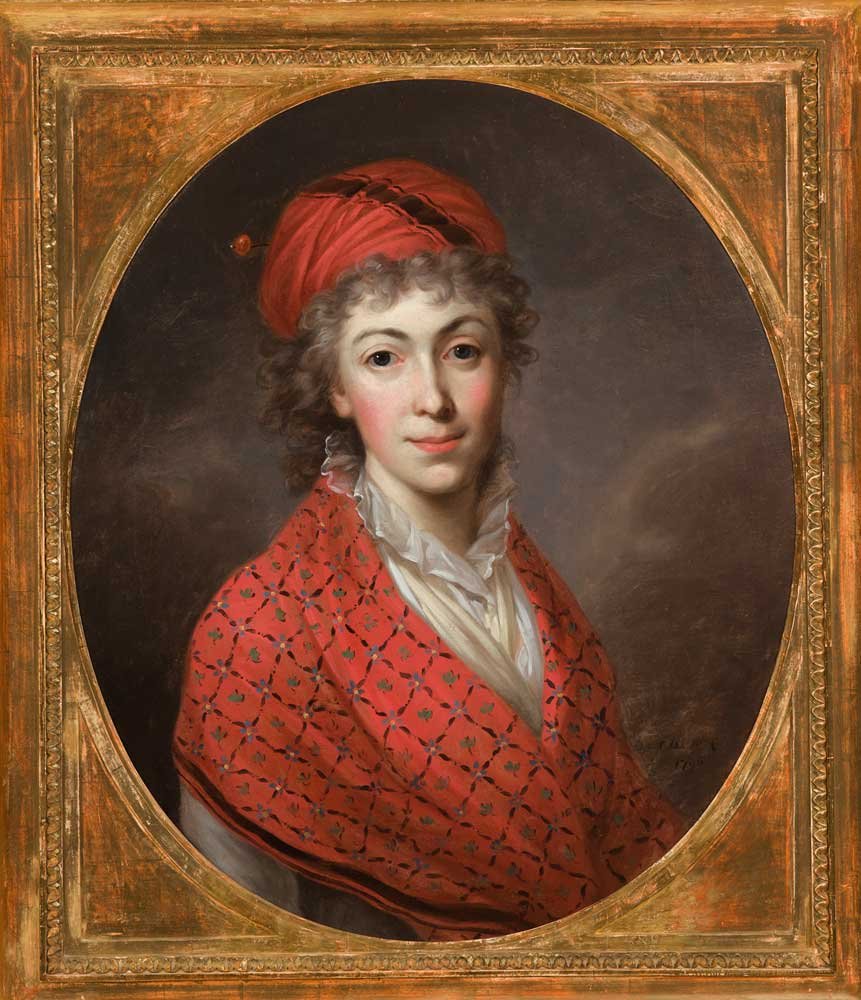 Portret olejny kobiety ukazanej w owalnym polu obrazu otoczonym zdobioną złotą ramą, na ciemnym tle, z krótkimi kręconymi włosami, w czerwonym turbanie i czerwonym wzorzystym szalu oraz białej marszczonej bluzce, z jasną cerą i różowymi policzkami, zwróconą twarzą ku oglądającemu.