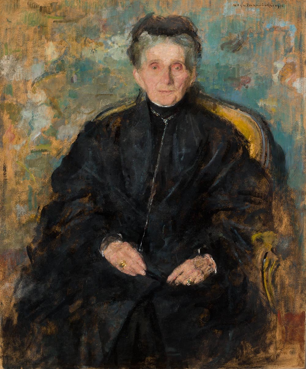 Portret olejny starszej kobiety siedzącej w złocistym fotelu, ubranej na czarno z małym czarnym nakryciem głowy, z siwymi włosami i jasną twarzą, dłonie z pierścionkami złożone na kolanach, na plamistym, wielobarwnym tle w tonach zieleni i brązu.