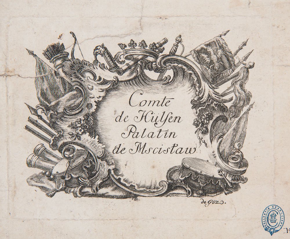 Ozdobny rytowany kartusz z kaligraficznym napisem Comte de Hülſen Palatin de Moscistaw, otoczony ornamentami z koroną u góry, chorągwiami, rogiem, kołczanem ze strzałami i bębnem na zmiętej, postarzałej kartce z niebieską pieczątką w prawym dolnym rogu.