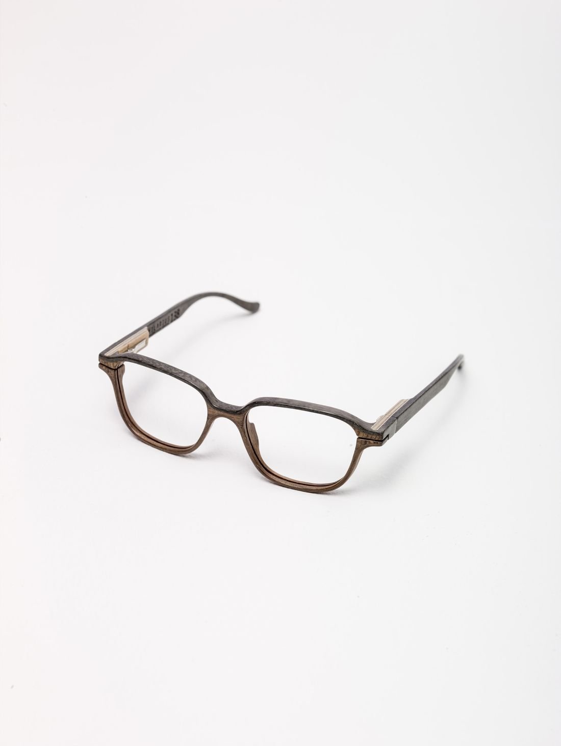 Brązowe okulary w prostokątno-owalnej oprawce z rozłożonymi zausznikami i widocznymi metalowymi zawiasami ułożone na białym tle.