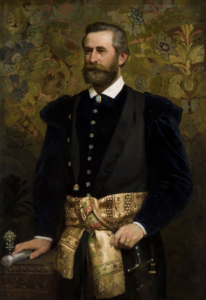 Portret stojącego mężczyzny z brodą i wąsami, w ciemnym aksamitnym kaftanie z białym kołnierzem i błękitną broszą, z rzędami ozdobnych guzików, szerokim złoto-kremowym, wzorzystym pasem przewiązanym w talii, prawą ręką opartą o stolik trzymającą zwój, lewą przy rękojeści miecza, na tle dekoracyjnego, kwiatowego gobelinu.