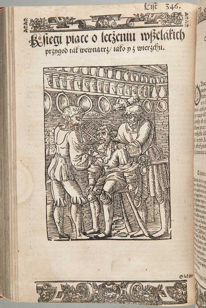 Strona starej drukowanej księgi z gotyckim nagłówkiem i numerem 346 oraz dużą drewnorytniczą ilustracją pokazującą trzech mężczyzn w historycznych strojach w wnętrzu z półkami wypełnionymi dzbanami i naczyniami — jeden siedzi na stołku, a dwaj stoją obok z rękami przy jego twarzy — otoczona dekoracyjnymi bordiurami u góry i u dołu strony.