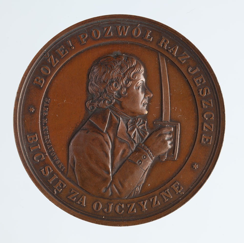 Okrągły brązowy medal z reliefowym bocznym profilem mężczyzny w odświętnym stroju trzymającego pionowo miecz; na otoku widoczny napis u góry "BOŻE! POZWÓL RAZ JESZCZE" i u dołu napis zawierający słowo "OJCZYZNĘ".