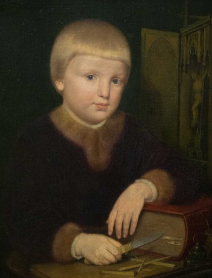 Portret dziecka z krótką blond fryzurą typu miseczka, ubranego w ciemny płaszcz z futrzanym kołnierzem i mankietami, w białych rękawiczkach opierającego jedną rękę na czerwonej książce i trzymającego nóż nad narzędziami na stole, na ciemnym tle z ozdobnym panelem zawierającym figurę.