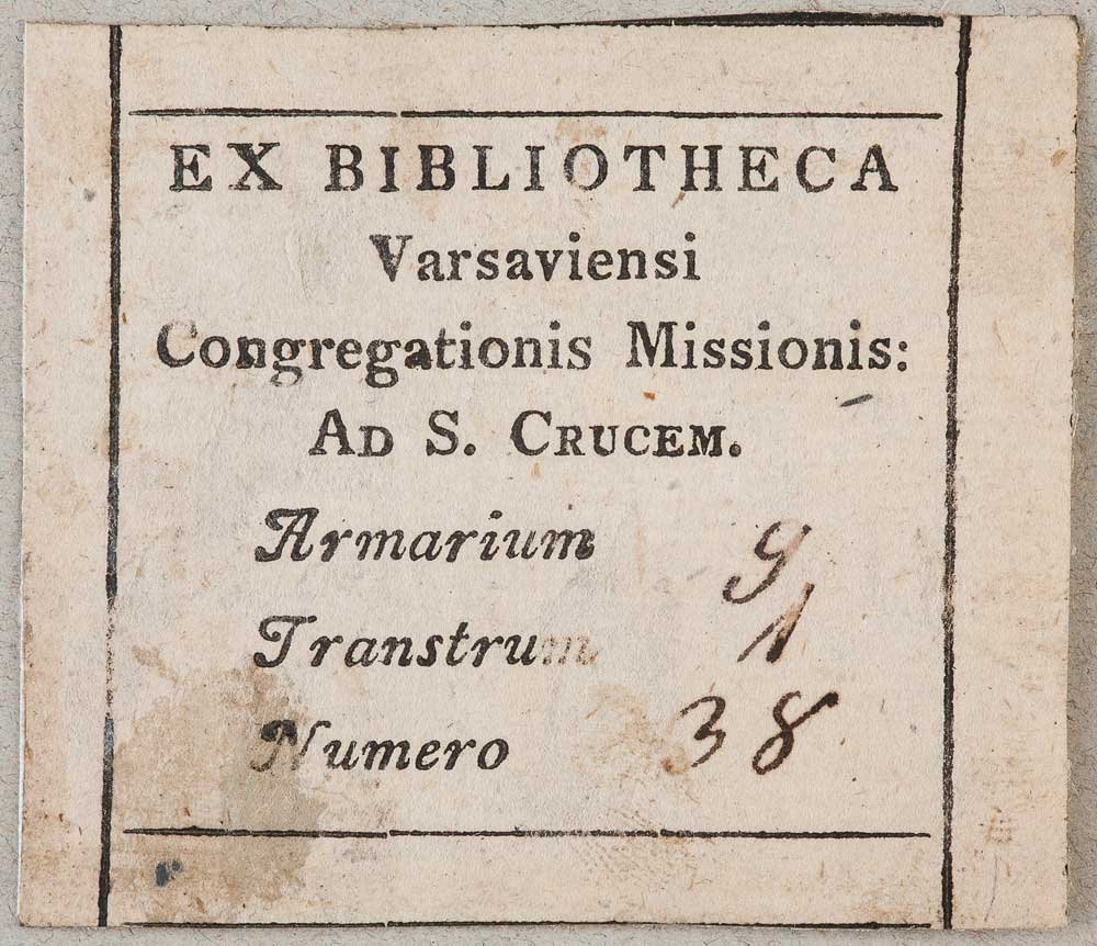 Mała prostokątna kremowa karta z czarnym drukowanym łacińskim napisem EX BIBLIOTHECA Varsaviensi Congregationis Missionis: Ad S. Crucem w cienkiej ramce, z odręcznymi cyframi po prawej stronie oraz śladami plam i przebarwień papieru.