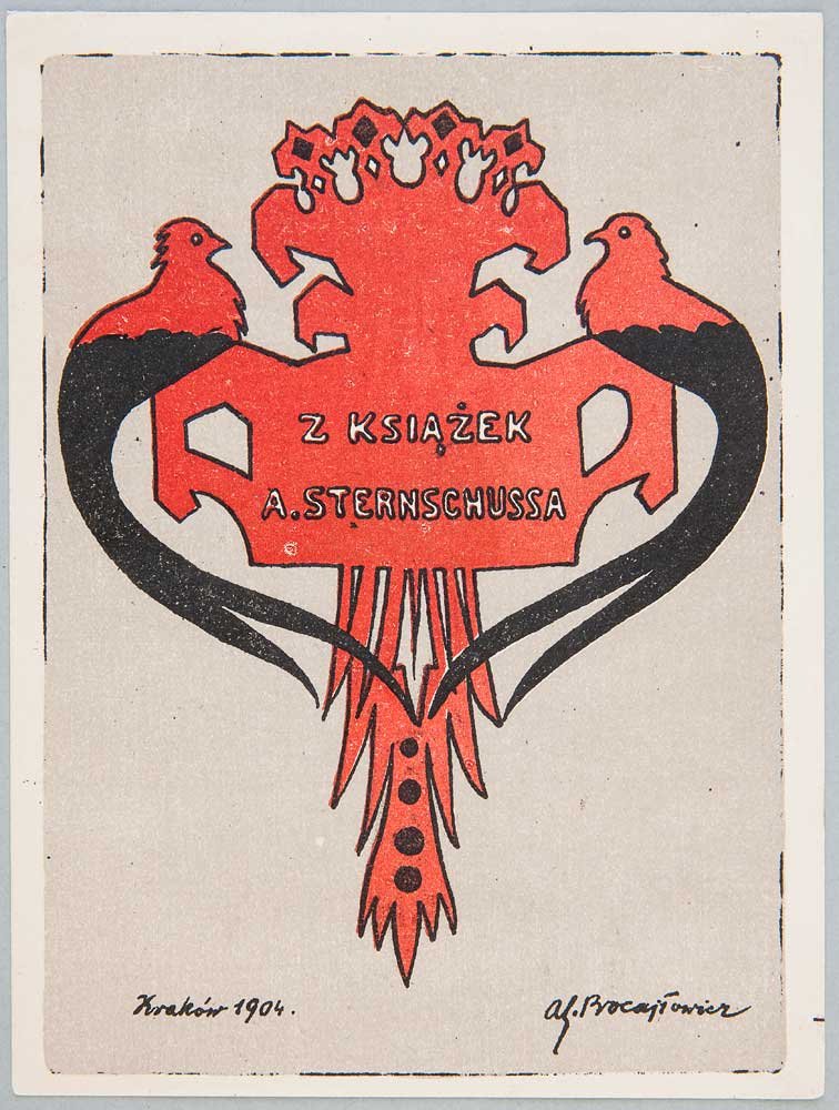 Grafika na beżowym tle przedstawiająca stylizowany czerwony ornament przypominający herb z dwoma czerwonymi ptakami po bokach, ich czarne wydłużone ogony tworzą symetryczne łuki, w centralnym polu napis "Z KSIĄŻEK A. STERNSCHUSSA", poniżej zwisający pióropusz z trzema czarnymi kropkami, w lewym dolnym rogu odręczny napis "Kraków 1904.", w prawym dolnym rogu widoczny podpis.