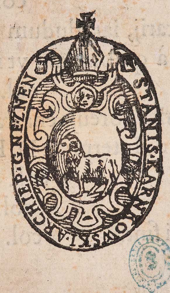 Owalny, czarny pieczętny stempel na pożółkłym papierze z zewnętrznym pierścieniem drukowanych wielkich liter, wewnętrznymi falistymi ornamentami, u góry nakrycie głowy z krzyżykiem i mała twarz poniżej, w centralnym polu stylizowane czteronożne zwierzę oraz częściowo widoczny niebieski okrągły tuszowy odcisk w prawym dolnym rogu.