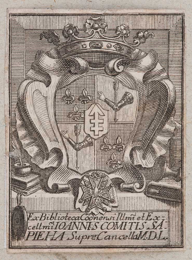 Grawerowany herb w ozdobnej tarczy pod koroną i płaszczem heraldycznym, tarcza ćwiartowana z liliami (fleur‑de‑lis) i dwiema zbrojnymi ramionami trzymającymi przedmioty, na środku mała tarczka z podwójnym krzyżem, poniżej medalion z emblematem, po bokach stosy książek i świecznik, a na dole prostokątna tablica z łacińskim napisem.