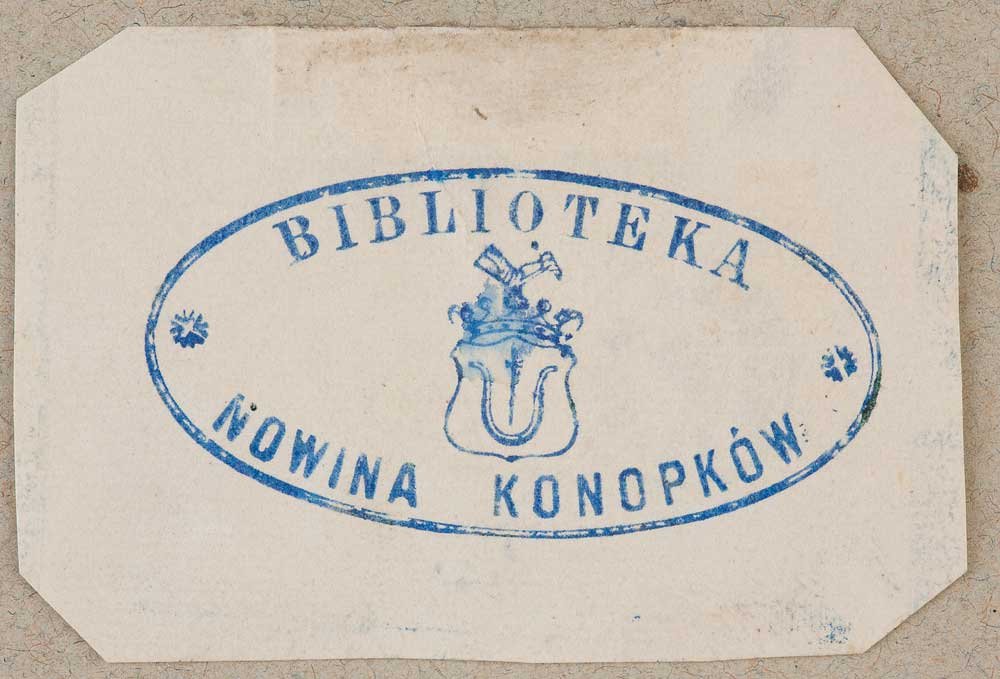 Niebieska owalna pieczęć na jasnobeżowej kartce ze ściętymi rogami, z napisem „BIBLIOTEKA” u góry, „NOWINA KONOPKÓW” u dołu, małymi rozetami po bokach i centralnie umieszczonym herbem z tarczą, hełmem i ozdobnym pióropuszem.