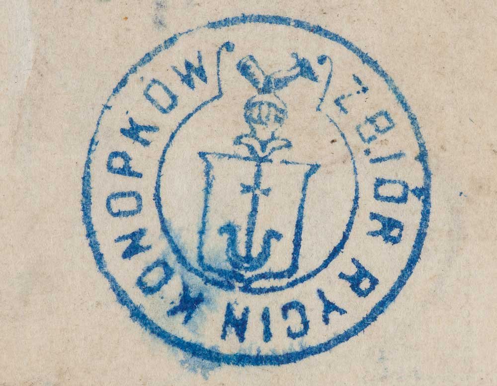 Odbity na papierze niebieski okrągły stempel z centralnym herbem — tarcza z kotwicą i pionowym krzyżem oraz hełmem z pióropuszem nad tarczą — i częściowo czytelnym dużym tekstem drukowanymi literami wzdłuż obręczy.