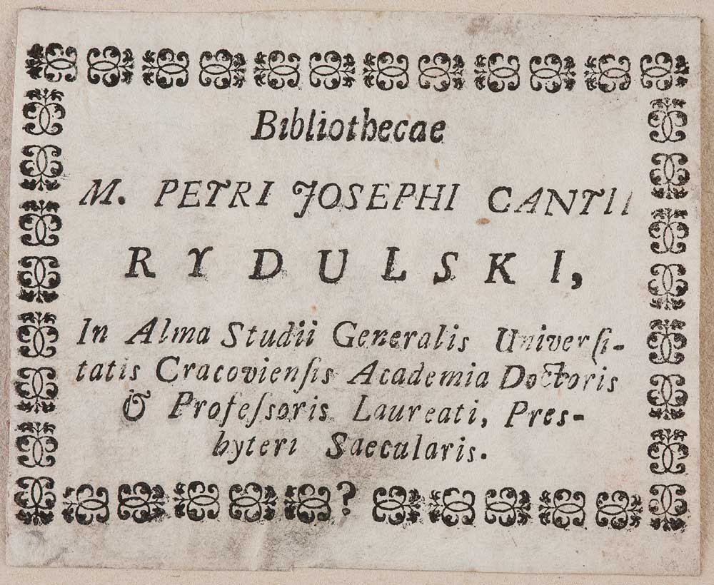 Pożółkły arkusz papieru z czarną ozdobną ramką z powtarzalnymi motywami roślinnymi i drukowanym tekstem łacińskim — na górze napis "Bibliothecae", poniżej większymi literami "M. PETRI JOSEPHI CANTII RYDULSKI," a dalej kilka linii mniejszego, kursywnego tekstu.