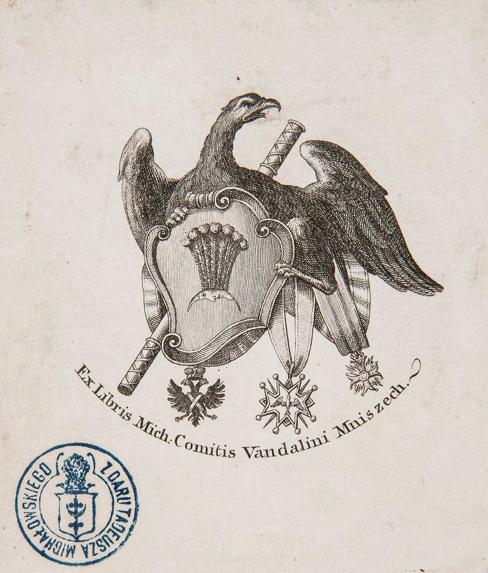 Grawerowany ex libris przedstawiający czarnego orła z rozpostartymi skrzydłami nad ozdobną tarczą z wiechą zboża, skrzyżowanymi mieczami i wstęgami oraz wiszącymi pod tarczą medalami i gwiazdą; pod tarczą łukowy napis Ex Libris Mich. Comitis Vandalini Mniszech.? oraz niebieska okrągła pieczęć z herbem w lewym dolnym rogu.