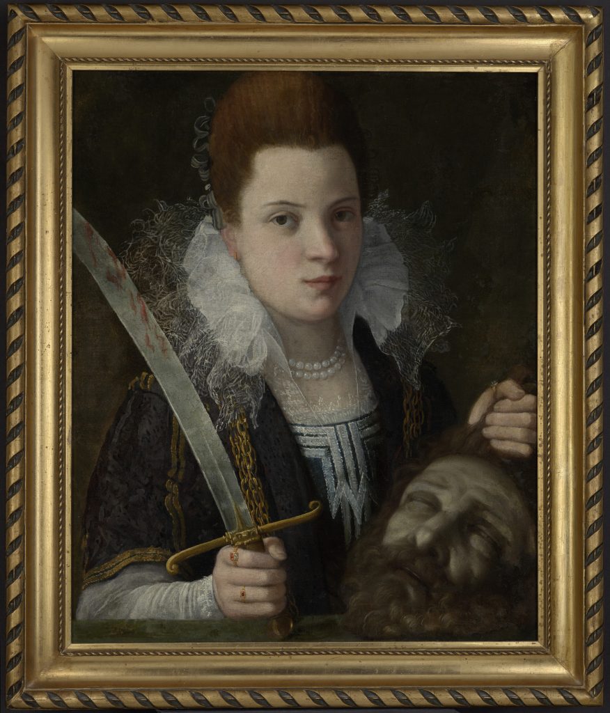 Portret kobiecej postaci w renesansowym stroju z wysoką kryzą i perłowym naszyjnikiem, trzymającej zakrwawiony miecz i odciętą głowę z zamkniętymi oczami, na ciemnym tle w ozdobnej złotej ramie.